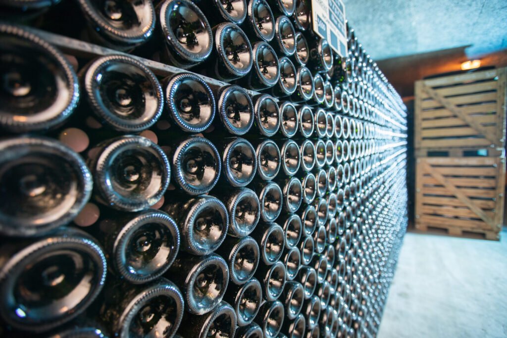 Alignement de bouteilles de vin empilées dans une cave.